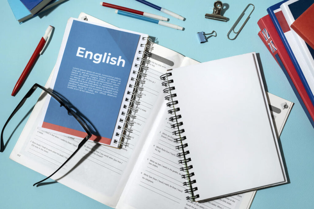 mesa de estudos com foco em materiais voltados para o aprendizado do idioma inglês e preparação para o TOEIC Speaking and Writing.